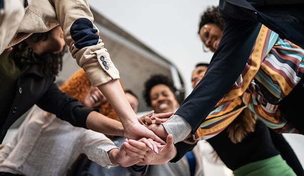 Diverse group of coworkers with stacked hands at the office
